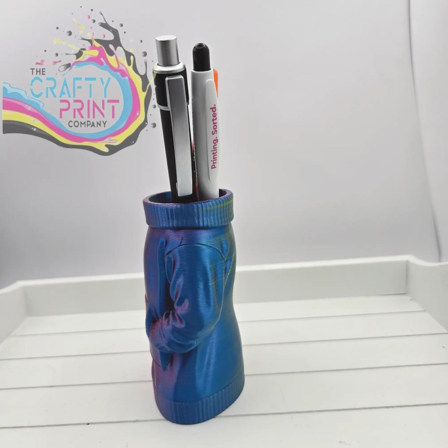 A vibrant blue and purple 3d printed jumper pen pot shaped like a sweater figure for desk organization