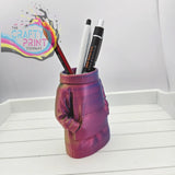 A vibrant iridescent purple and pink 3d printed jumper pen pot shaped like a sweater for desk organization