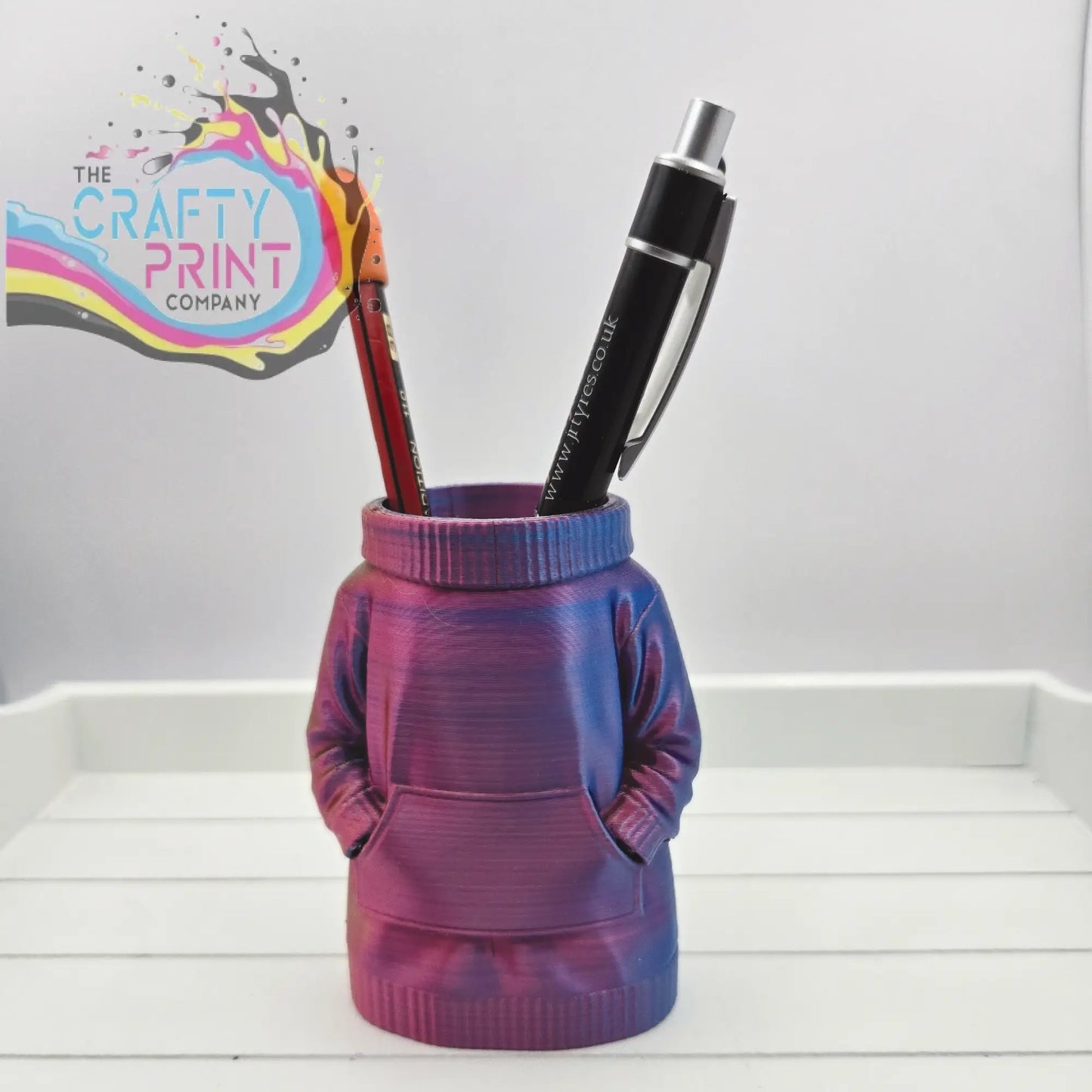 A vibrant iridescent purple and blue 3d printed jumper pen pot with ribbed collar and front pockets for desk organization