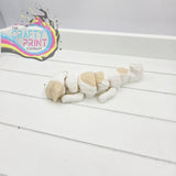 A charming white and beige ceramic shih tzu dog figurine sleeping in smooth rounded segments for keyring or fidget use