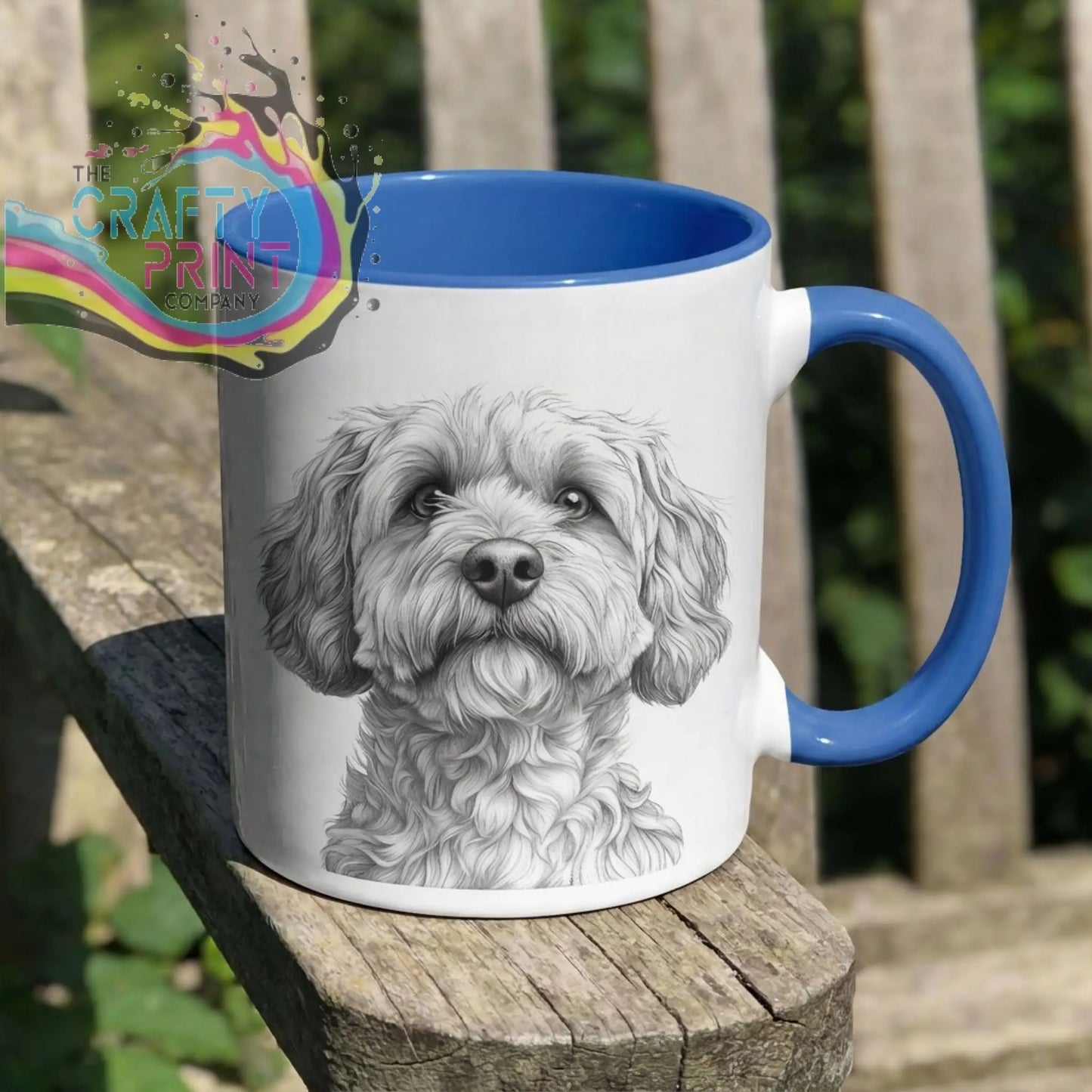 White ceramic cockapoo pencil drawing mug with blue handle and interior featuring a fluffy dog’s face sketch