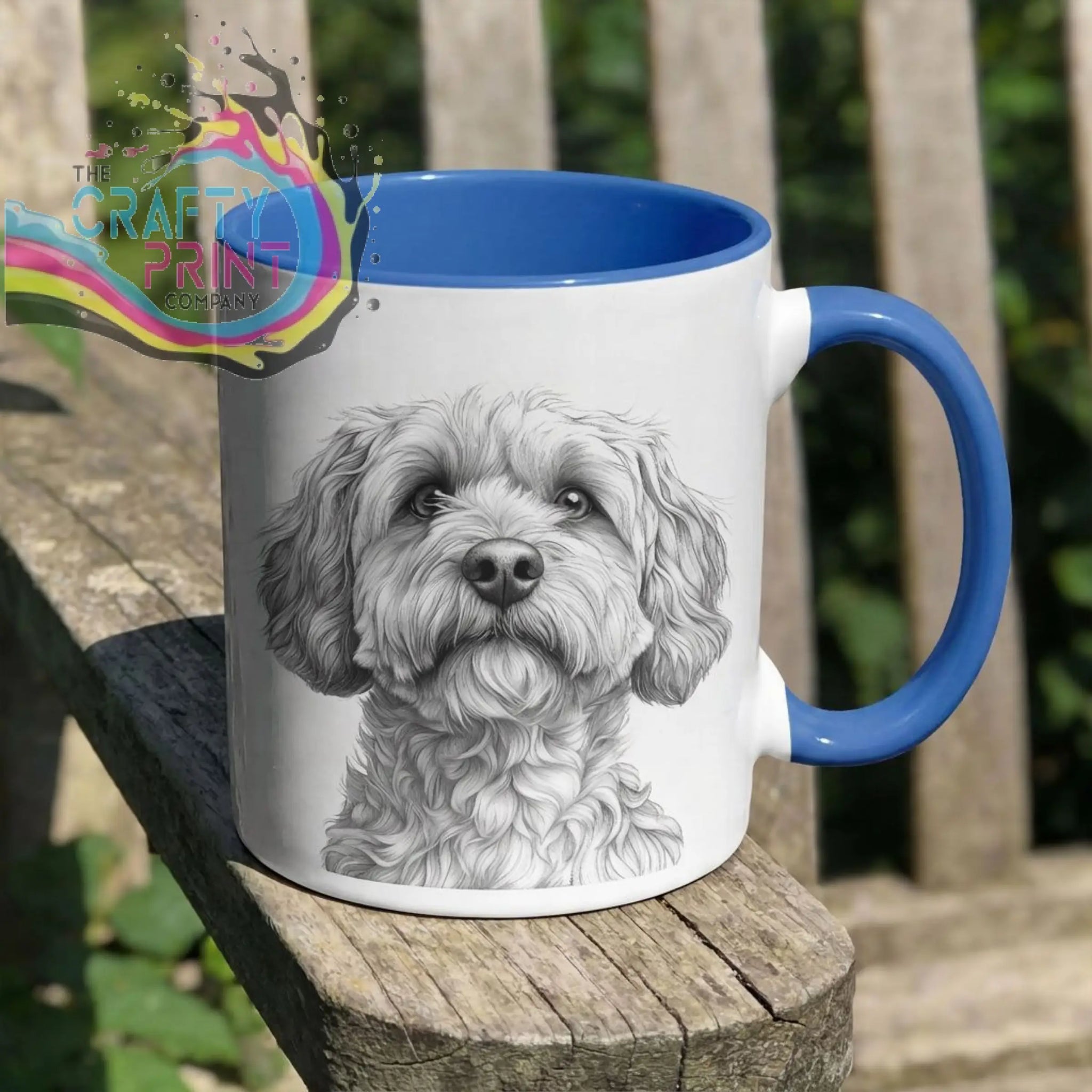 White ceramic cockapoo pencil drawing mug with blue handle and interior featuring a fluffy dog’s face sketch
