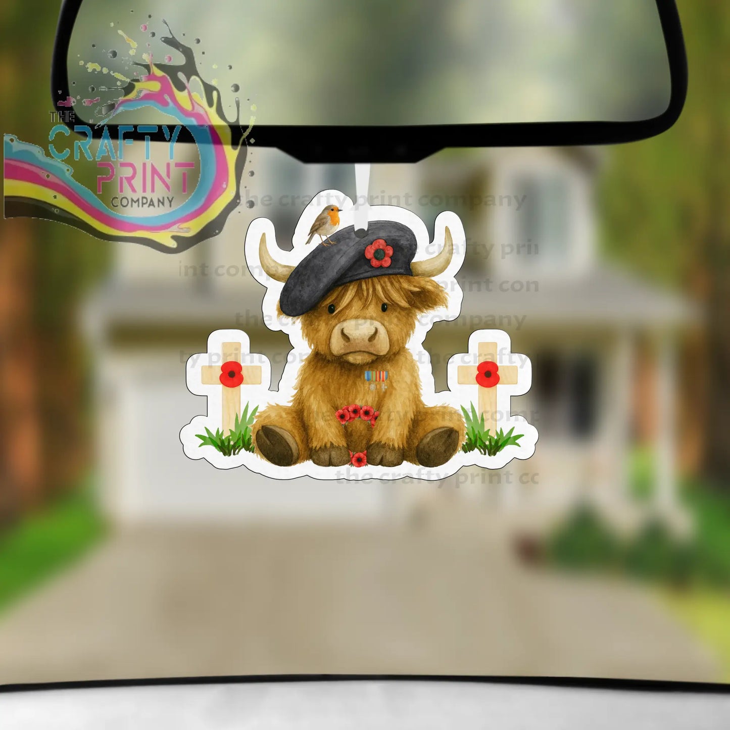 Brown highland cow car air freshener wearing black beret with red poppy between white crosses with red poppies