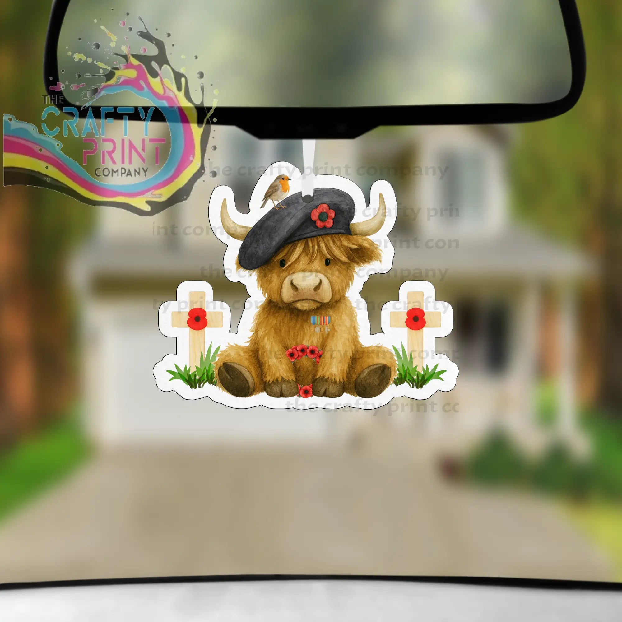 Brown highland cow car air freshener wearing black beret with red poppy between white crosses with red poppies