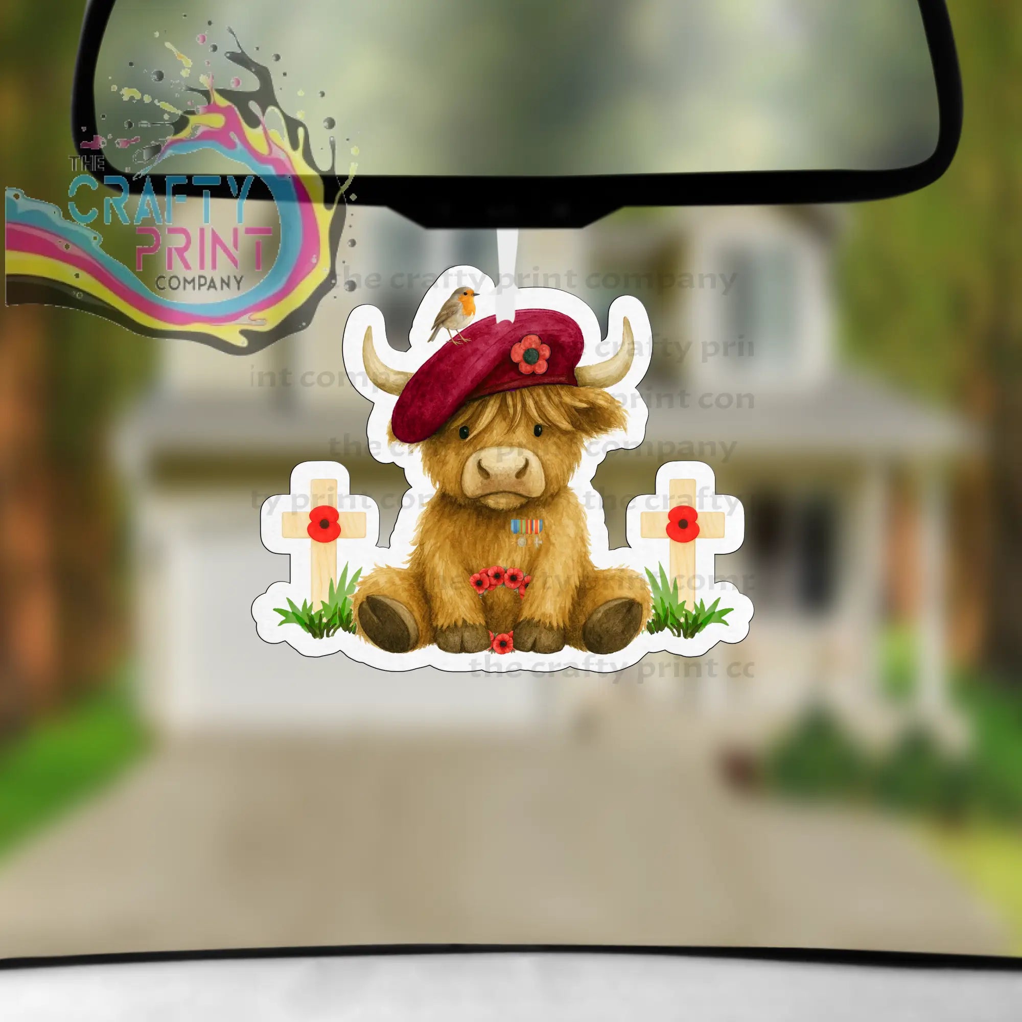 Cute brown highland cow car air freshener with red beret and poppy decorated white crosses for remembrance use