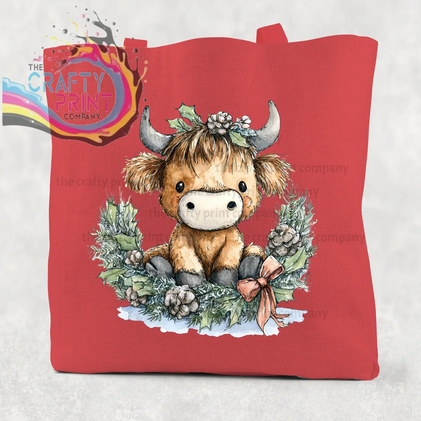 Red canvas cotton tote bag featuring a highland cow wreath with a brown highland cow and festive holly accents
