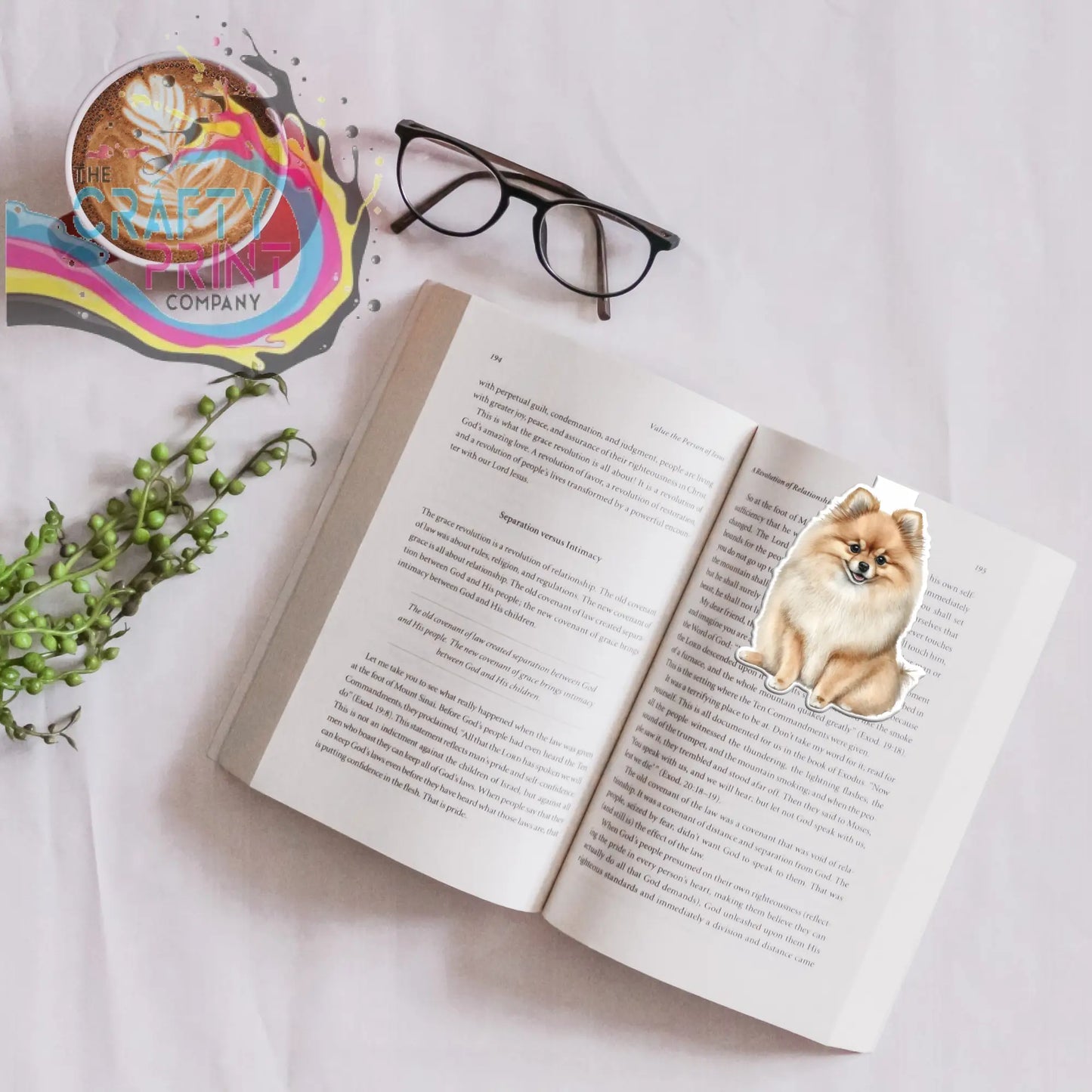 A charming pomeranian magnetic bookmark with soft tan and cream fur design on an open book page