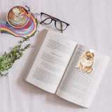 A charming pomeranian magnetic bookmark with soft tan and cream fur design on an open book page