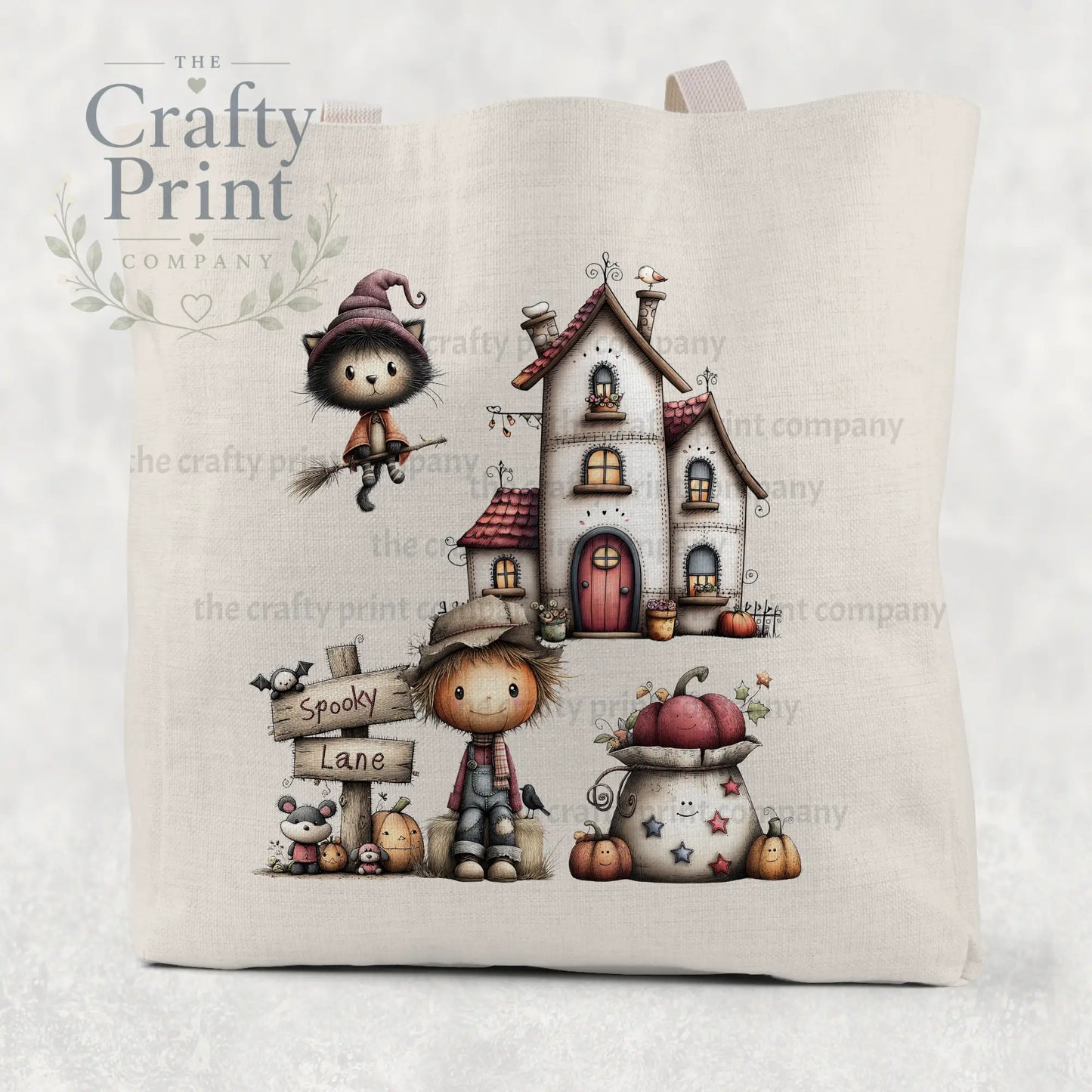 Beige cotton re-usable tote bag featuring spooky lane halloween illustration with witch cat, scarecrow, pumpkins, and house