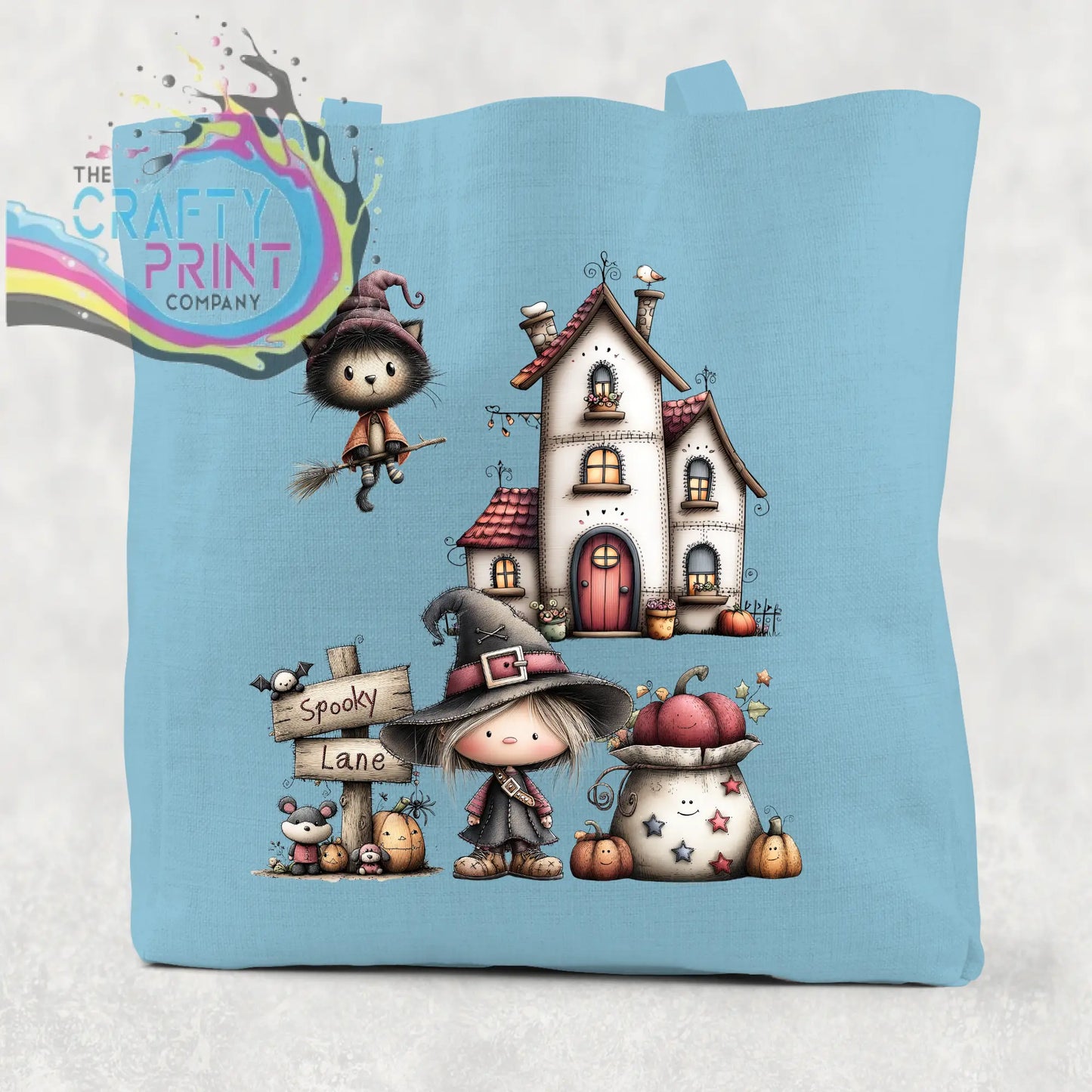 Light blue cotton re-usable tote bag with spooky lane halloween witch illustration of witches pumpkins and house
