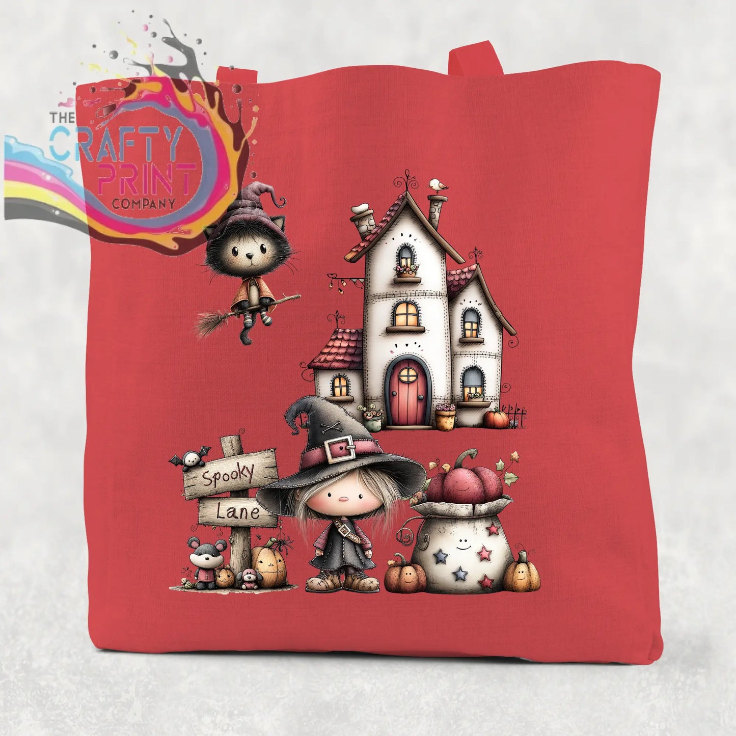 Red cotton re-usable tote bag featuring a spooky lane halloween illustration of witches haunted house and pumpkins