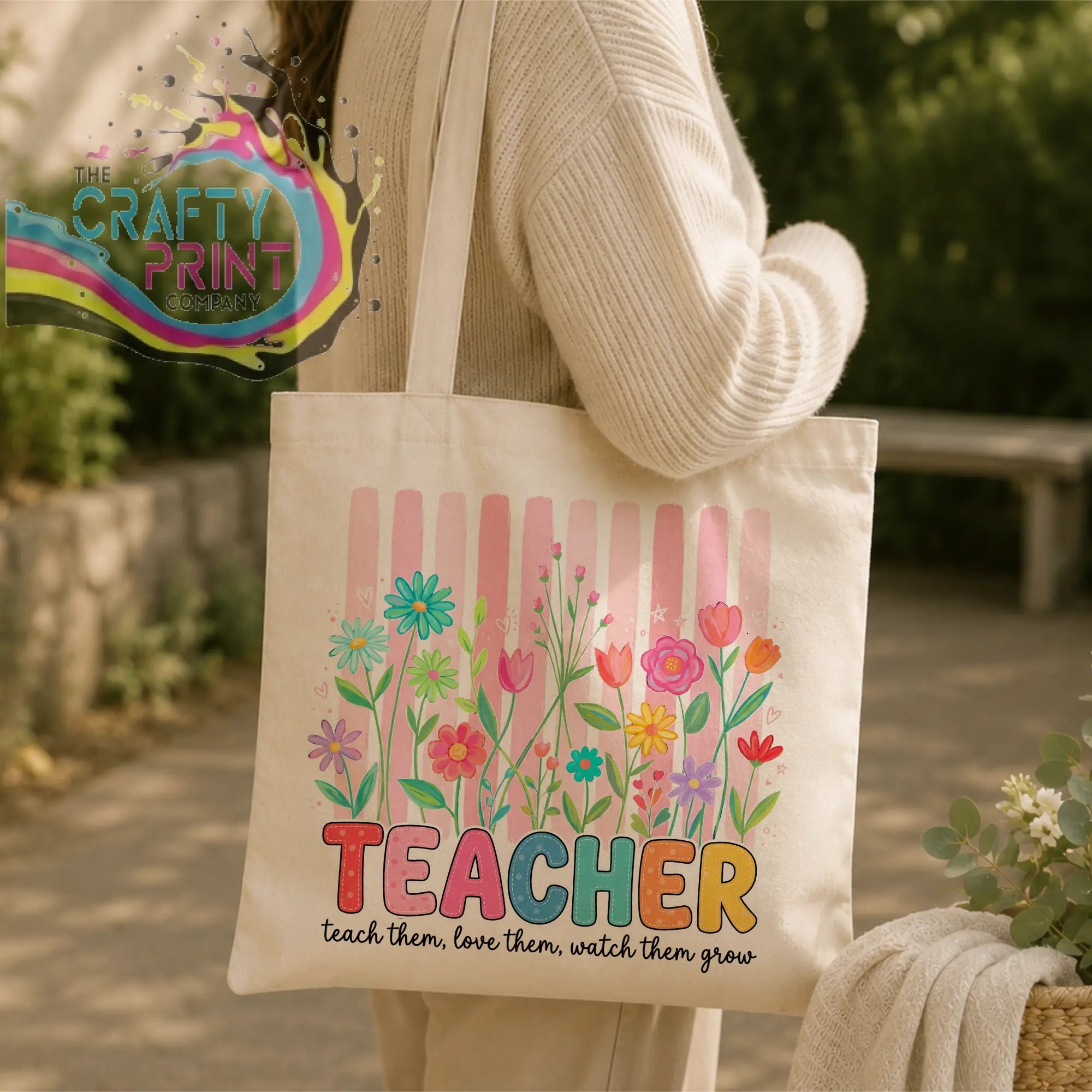 Cream-colored canvas re-usable tote bag with vibrant floral design and rainbow teacher lettering