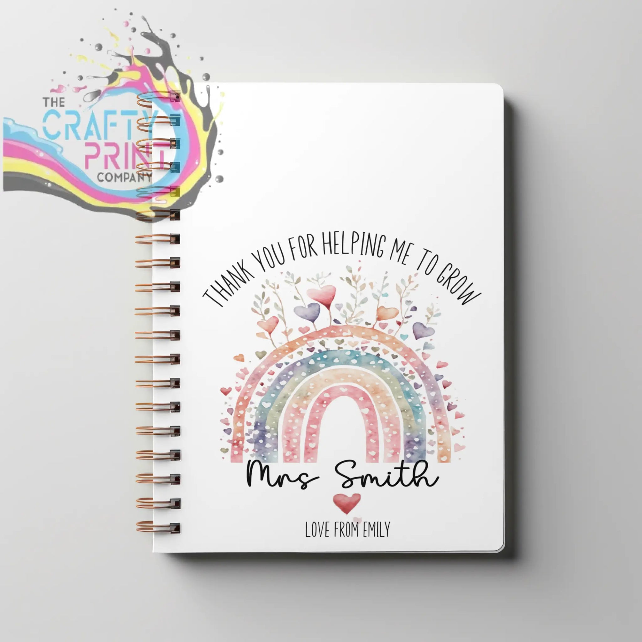 A white grow a5 spiral notebook with spiral binding featuring a watercolor rainbow design and a thank you message