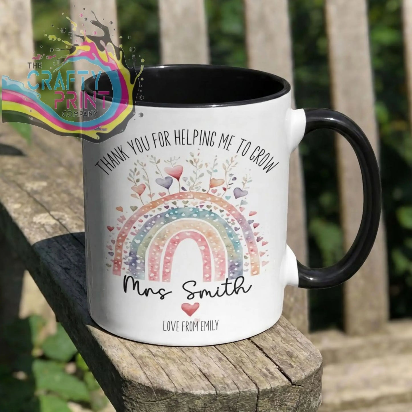 A white ceramic grow mug with black handle and interior featuring a colorful rainbow design and thank you message for teachers