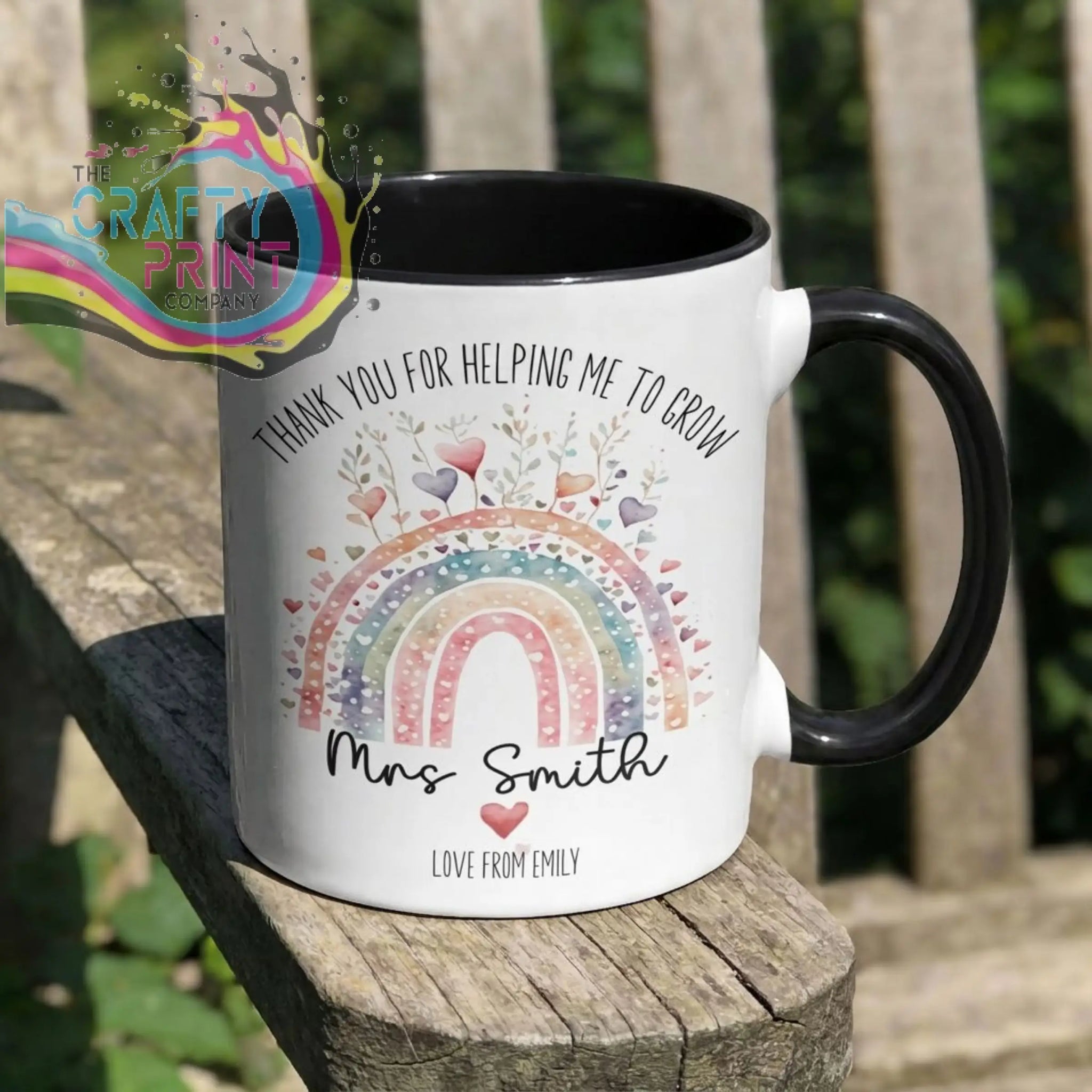 A white ceramic grow mug with black handle and interior featuring a colorful rainbow design and thank you message for teachers